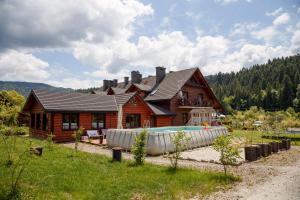 una casa de madera con piscina frente a ella en Solny - Resort w Bieszczadach en Cisna