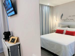 1 dormitorio con 1 cama con almohadas rojas y TV en Marina Atico Penthouse, en Puerto de la Cruz