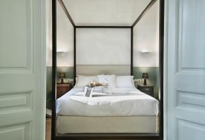 una camera da letto con un grande letto bianco con struttura metallica di ATHINAIDOS QUARTERS by K&K ad Atene