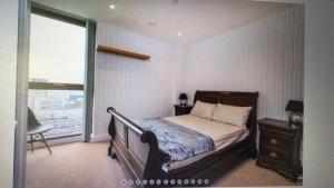 um quarto com uma cama e uma grande janela em LUXURY SERVICED APARTMENT***** em Croydon