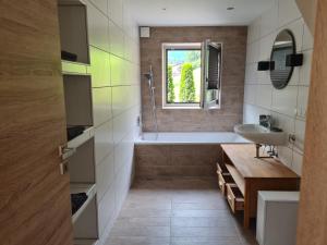 ein Badezimmer mit einer Badewanne und einem Waschbecken in der Unterkunft Ferienwohnung Berghäusl in Bischofswiesen