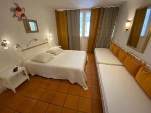 une chambre avec un lit blanc et un canapé dans l'établissement Studio Anse des Rochers, à Saint-François