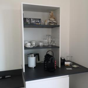 a kitchen counter with a coffee maker on a shelf at Haus Marvin in Döttingen