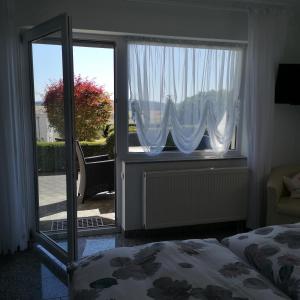 1 dormitorio con 1 cama y puerta corredera de cristal en Haus Marvin, en Döttingen