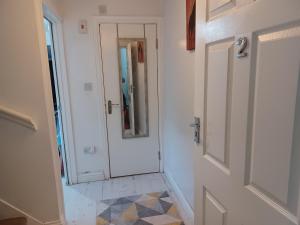 a bathroom with a door with a mirror and a tiled floor at Haven Mills 2 in Gillingham