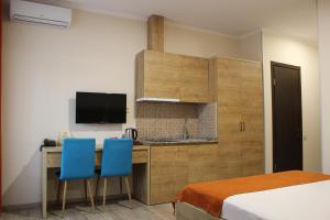 a bedroom with a desk and two blue chairs at Boutique Hotel 32 in Batumi