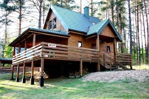 a large wooden house in the middle of a forest at Domki-Mazury in Pasym