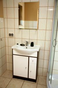 a bathroom with a white sink and a mirror at Domki-Mazury in Pasym