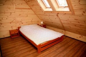 a bedroom with a bed in a wooden room at Domki-Mazury in Pasym