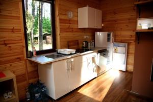 a kitchen with white cabinets and a window in a cabin at Domki-Mazury in Pasym