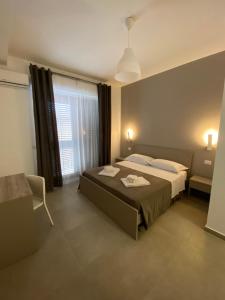 a bedroom with a large bed and a window at AEROPORTO KATANÈ ROOMS in Catania