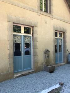 uma entrada para um edifício com portas azuis em Cottage Desmaisons em Saint-Just-le-Martel