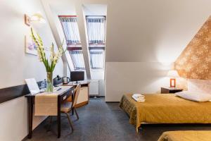 een hotelkamer met een bed en een bureau en een bed en een bureau bij Hotel Pod Kasztanami in Lublin