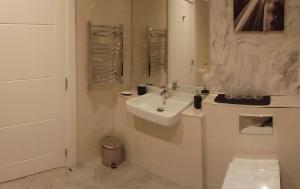 Baño blanco con lavabo y espejo en Kilfane Country Lodge, en Kilkenny