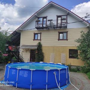 een huis met een zwembad ervoor bij U Nazara in Slavske