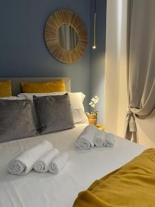 a bed with three rolled towels on top of it at Happy Family Apartments San Pietro in Genova
