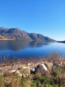 a view of a lake with mountains in the background at Le Petit Bijou Boutique Apartments - Solar Power in Franschhoek