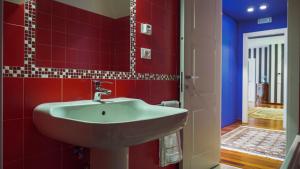 bagno con lavandino e parete rossa di Chez Nous L'Aquila Casa vacanze a L'Aquila Altre 27 foto