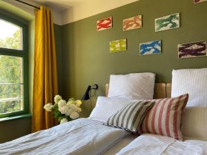 a bedroom with two beds and pictures on the wall at traumHaff- Endless Summer Loft, privates NORDICSPA, Kamin, Hund, 400m zum Wasser in Rieth