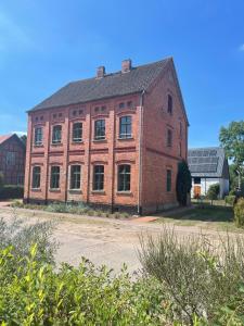 a large red brick building with a roof at traumHaff- Endless Summer Loft, privates NORDICSPA, Kamin, Hund, 400m zum Wasser in Rieth