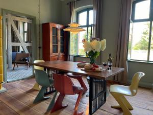 a dining room with a wooden table and chairs at traumHaff- Endless Summer Loft, privates NORDICSPA, Kamin, Hund, 400m zum Wasser in Rieth