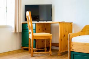 a room with a desk with a television and a chair at Hotel & Restaurant Brauner Hirsch Osterwieck in Osterwieck