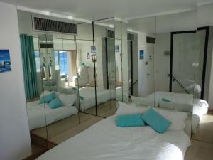 カンヌにあるLe Panoramer Sea Viewのベッドルーム1室(ベッド2台、大きな鏡付)