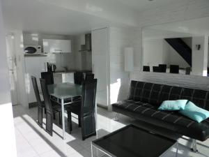 a living room with a black couch and a table at Le Panoramer Sea View in Cannes