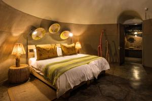 Twyfelfontein的住宿－Camp Kipwe，卧室配有一张床,墙上有两面镜子