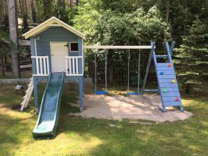 a playground with a slide and a play house at Domki-Mazury in Pasym