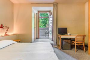 a bedroom with a bed and a desk with a computer at Albergo Sorriso in Boario Terme