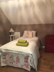 1 dormitorio con 1 cama con toallas verdes en Cottage Desmaisons en Saint-Just-le-Martel