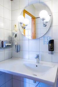 a bathroom with a sink and a mirror at Hotel & Restaurant Brauner Hirsch Osterwieck in Osterwieck