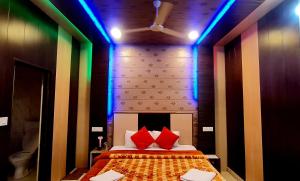 a bedroom with a bed with red pillows and blue lights at Rashal Homes in Shogi
