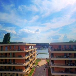 two apartment buildings next to a body of water at Snagov Lake Sonnio Properties in Turbaţi