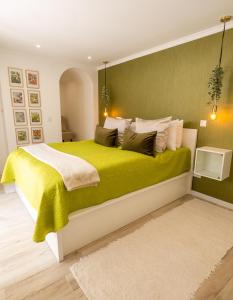 a bedroom with a large bed with a green wall at Little Townsuite Funchal in Funchal