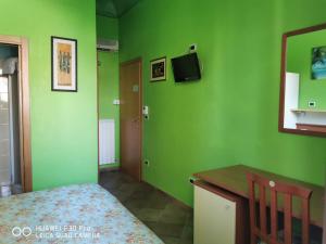 a bedroom with green walls and a bed and a desk at Porto Recanati Zimmer in Porto Recanati