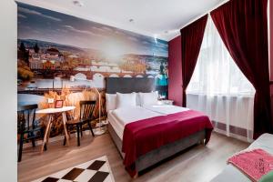 una habitación de hotel con una cama grande y una pintura en la pared en Revelton Studios Prague, en Praga