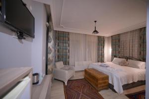 a hotel room with a bed and a tv at Pashabelle Hotel in Goreme