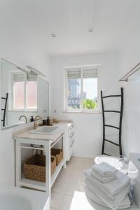 een witte badkamer met een wastafel en een stoel bij Casa Boma Lisboa - Lighting Apartment with Private Balcony - Campolide I in Lissabon