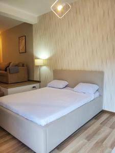 1 dormitorio con 1 cama blanca grande y 1 sofá en Sleep and drive premium, en Sarajevo
