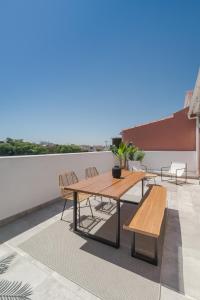 een houten tafel en banken op een dak bij Casa Boma Lisboa - Lighting Apartment with Private Balcony - Campolide I in Lissabon