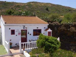 una pequeña casa blanca con techo rojo en Casa Goliath en Isora