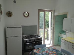eine Küche mit einem Herd, einem Tisch und einem Fenster in der Unterkunft Villa Florida in Fiuggi