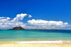 Blick auf den Strand mit einem Berg im Hintergrund in der Unterkunft Casa Yoaki in Corralejo
