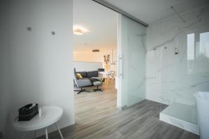 ein Badezimmer mit weißen Wänden und ein Wohnzimmer in der Unterkunft Hotel in Herrenhausen in Hannover