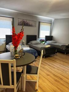 Apartament Adabet في كيبنو: غرفة معيشة بسريرين وطاولة وكراسي
