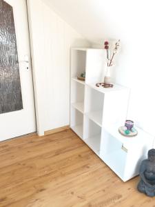 a white book shelf in a room with a door at Apartment, Boxspringbett, ruhige Lage, Kassel Nähe in Schauenburg
