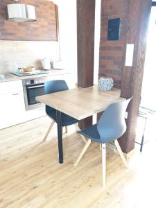 a kitchen with a wooden table and two chairs at Apartment, Boxspringbett, ruhige Lage, Kassel Nähe in Schauenburg