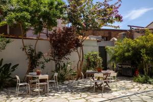 a patio with tables and chairs in a garden at MeMeraki Artist Residency in Limassol